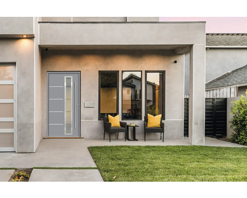 Moderne Hausfassade mit Haustür, Fenstern und Sitzgelegenheit im Freien.