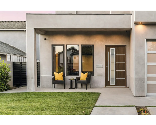 Hausfassade mit Haustür, Fenstern und Sitzgelegenheit im Freien