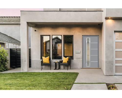 Moderne Hausfassade mit Haustür, Fenstern und Sitzbereich im Freien