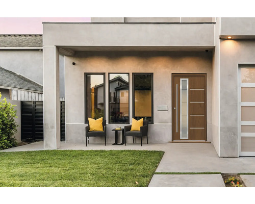 Fassade eines Hauses mit Haustür, Fenstern und Sitzgelegenheit