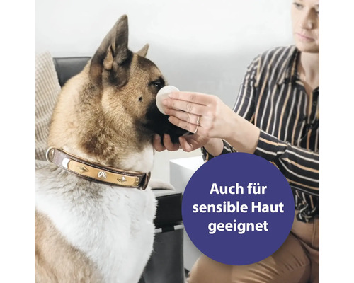 Frau reinigt Hund mit einem Wattepad. Das Produkt ist auch für sensible Haut geeignet.