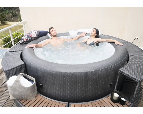 Paar entspannt im aufblasbaren Whirlpool auf der Terrasse
