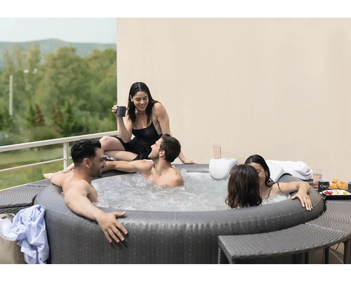 Aufblasbarer Whirlpool mit mehreren Personen im Freien auf einer Terrasse.