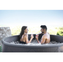 Paar entspannt mit Getränken im Whirlpool