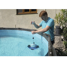 Mann bedient einen Poolreiniger in einem Pool