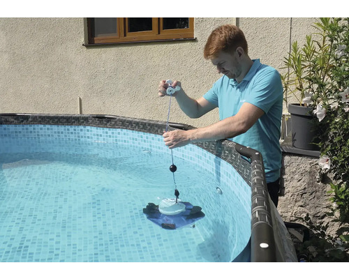 Mann bedient einen Poolreiniger in einem Pool