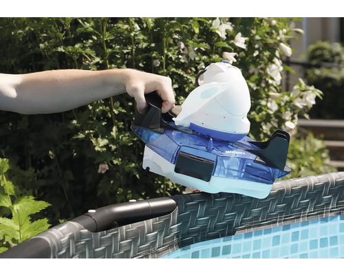 Eine Hand setzt einen Poolreiniger auf den Rand eines Pools.