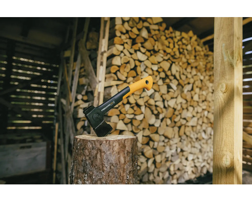 Spalthammer auf Holzscheit vor einem Holzstapel