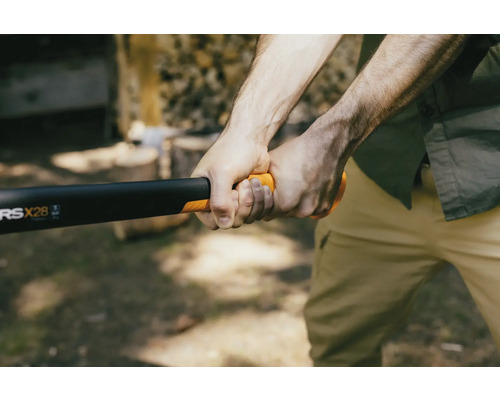 Eine Person hält eine Spaltaxt von Fiskars zum Holzspalten.