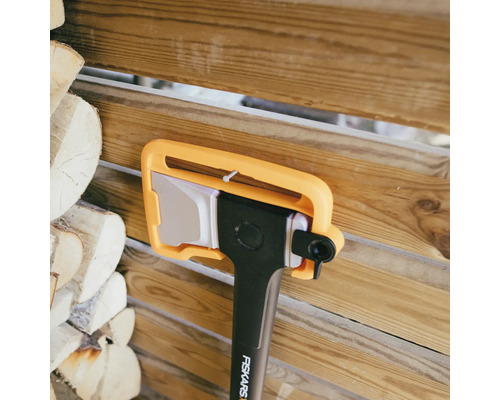 Fiskars Axt mit Klingenschutz vor Holzwand