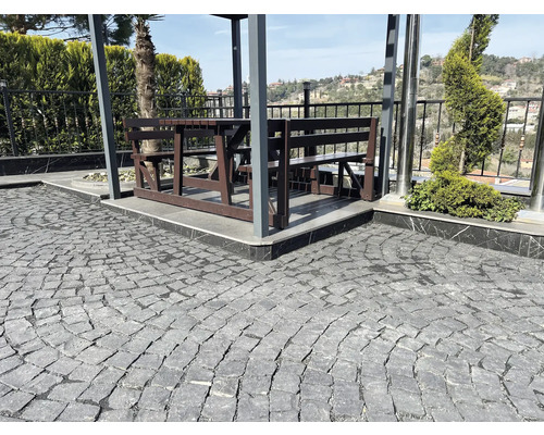 Gartenbereich mit Pflastersteinen, Sitzgruppe und Pflanzen