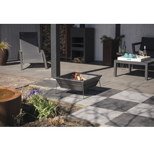 Terrassenszene mit Feuerstelle, Gartenmöbeln und dekorativen Elementen.