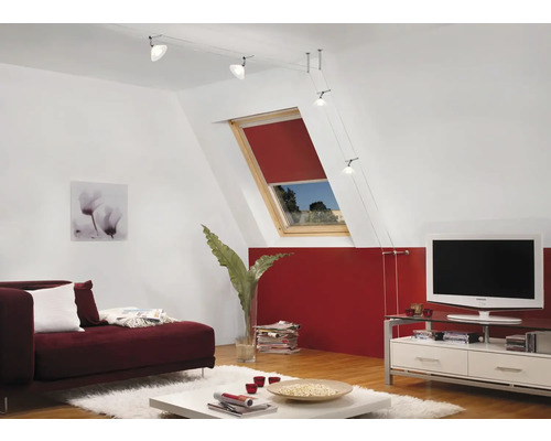 Wohnzimmer mit Dachfenster, rotem Rollo, Sofa und Seilsystemleuchte