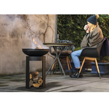 Feuerschale mit Holz und Frau im Garten