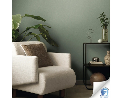 Wohnzimmer mit grüner Vliestapete, Sessel und Beistelltisch