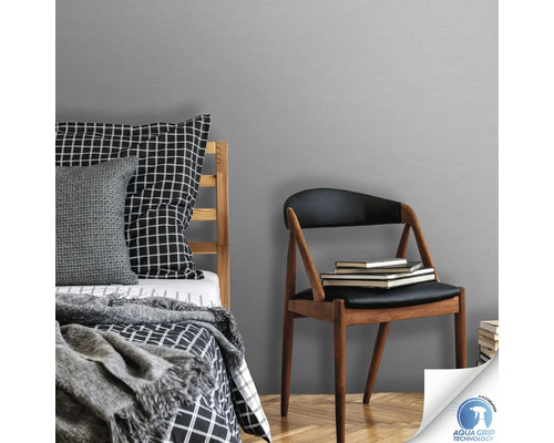 Schlafzimmer mit Bett, Stuhl und grauer Vliestapete