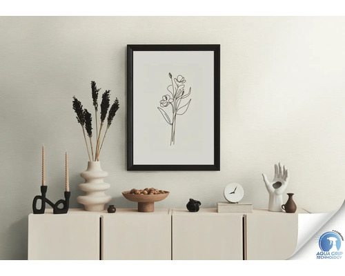 Dekoratives Stillleben mit Rahmen, Trockenblumen, Kerzen und Figuren auf einem Schrank.