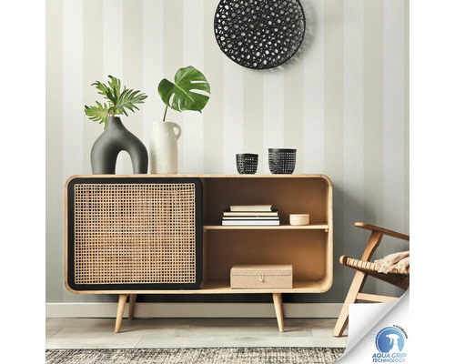 Anrichte aus Holz mit Rattantür vor einer gestreiften Wand