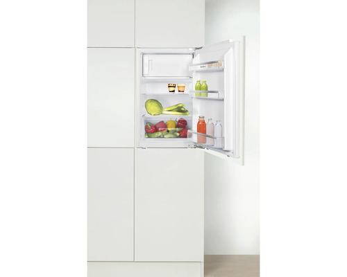 Integrierter Kühlschrank mit geöffneter Tür, gefüllt mit Lebensmitteln.