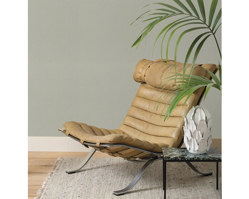 Ledersessel auf Metallgestell neben Beistelltisch mit Pflanze