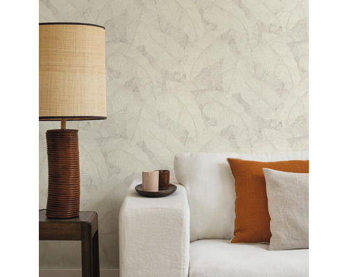 Wohnraum mit Sofa, Kissen, Tischlampe und Tapete mit Blattmuster