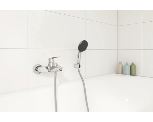 Aufputz-Brausebatterie mit Handbrause in einem Badezimmer mit weißen Fliesen.