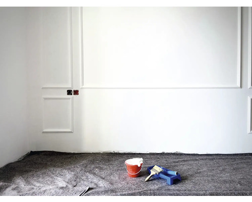 Renovierungsarbeiten in einem Raum mit Farbeimer, Farbroller und Abdeckvlies