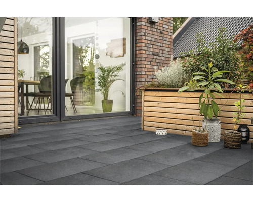 Terrasse mit grauen Betonplatten, Holzelementen und Pflanzen