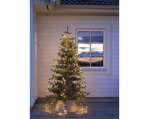 Weihnachtsbaum mit Lichterkette im Aussenbereich vor einem Fenster