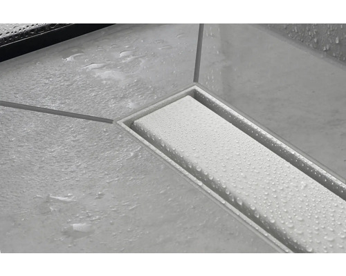 Duschrinnenablauf mit Wasser auf Fliesen