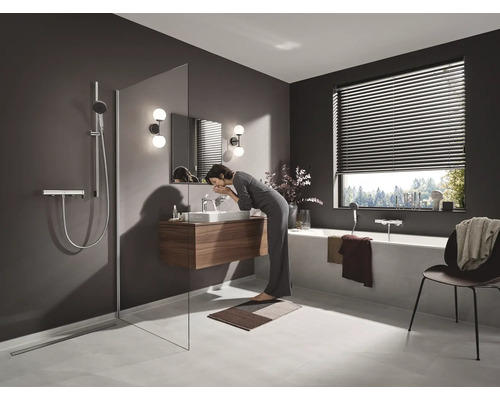 Badezimmer mit Dusche, Waschtisch, Badewanne und Fensterjalousie