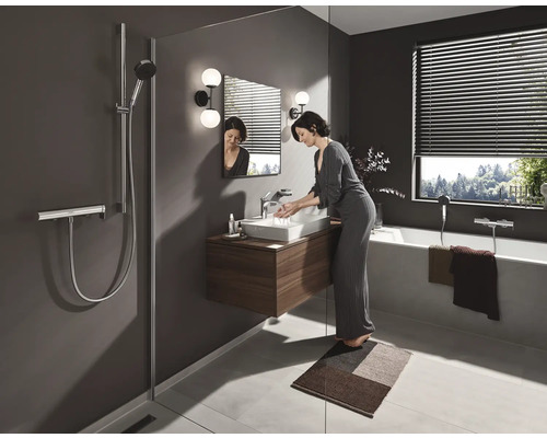 Badezimmer mit Dusche, Waschbecken, Spiegel, Badewanne und Frau