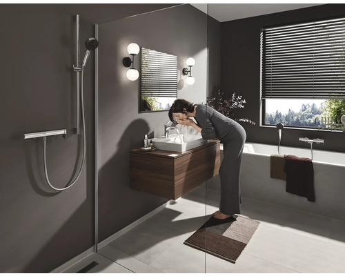 Badezimmer mit Dusche, Waschbecken, Spiegel, Beleuchtung, Badewanne und Jalousien