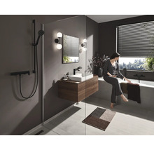 Badezimmer mit Dusche, Waschbecken, Badewanne und entspannender Frau