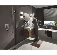 Modernes Badezimmer mit Dusche, Waschbeckenunterschrank, Badewanne und einer Frau vor dem Spiegel