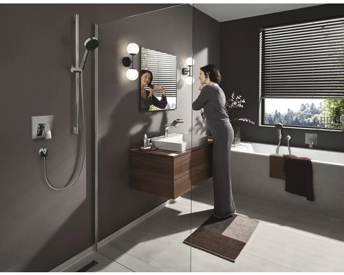 Modernes Badezimmer mit Dusche, Waschbeckenunterschrank, Badewanne und einer Frau vor dem Spiegel