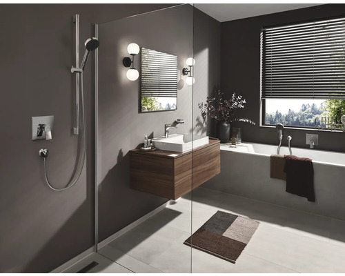 Badezimmer mit Dusche, Waschbeckenunterschrank, Badewanne und Fenster mit Jalousien.