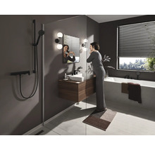 Helles Badezimmer mit Dusche, Waschbecken, Spiegel, Badewanne und einer Frau