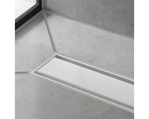 Detailaufnahme eines Entwässerungssystems im Boden eines Badezimmers.