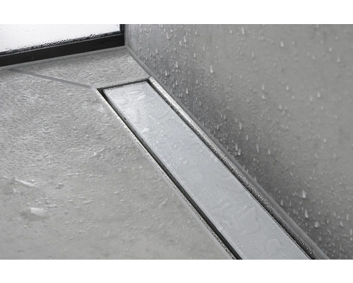 Bodenebene Dusche mit Entwässerungsrinne aus Metall und Fliesenboden.