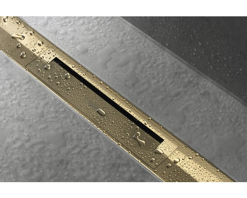 Goldene Duschrinne mit Wasserperlen auf Fliesenboden