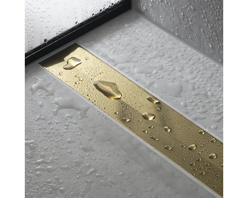 Goldene Duschrinne mit Wasserperlen auf hellem Untergrund