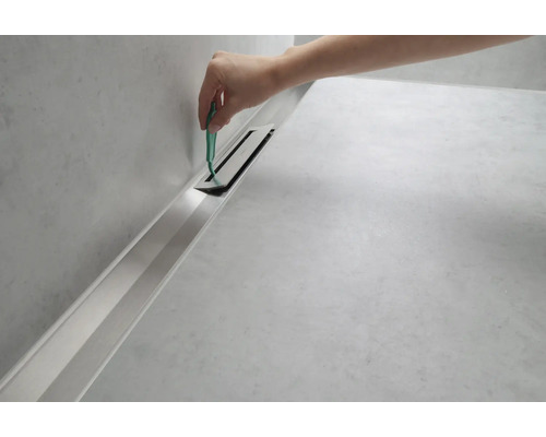 Reinigungswerkzeug wird in eine Duschrinne eingeführt