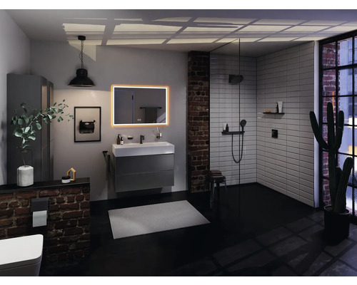 Badezimmer mit Waschtisch, Spiegel, Dusche und Ziegelwand