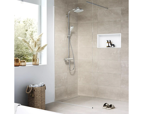 Begehbare Dusche mit Duscharmatur, eingebauter Nische, Handtüchern und Dekoration in einem hellen Badezimmer