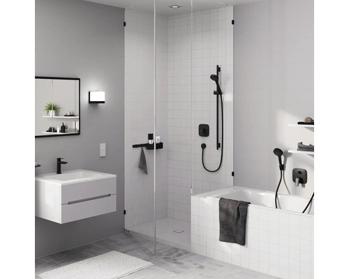 Badezimmer mit Badewanne, Dusche, Waschbecken, Spiegelschrank und Handtüchern