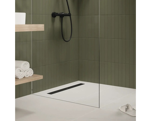 Modernes Badezimmer mit Dusche, Duschrinne, Handtüchern und Ablageflächen.