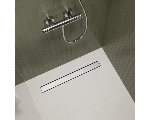 Badezimmer mit Duscharmatur, gefliester Wand und Duschrinne