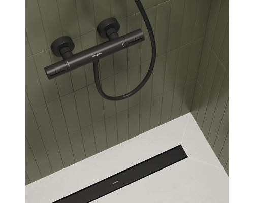 Aufputz Duscharmatur mit Brauseschlauch und Duschrinne im Duschbereich.