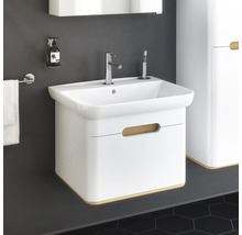 Weißer Waschtisch mit Armatur, Seifenspender und Handtuchhalter im Badezimmer.